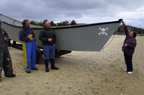 At Barnes Landing on Sunday, Susan Denton christened the Miss Mary with a bottle of Budweiser. Her husband, Dwayne Denton, built the new dory for Paul and Dan Lester.