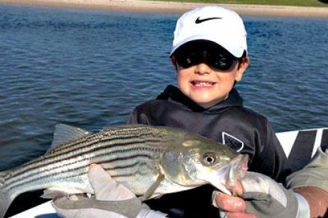 Andrew Mark, 7, landed his first fish — a striped bass — on a spinning road he had just learned to use.