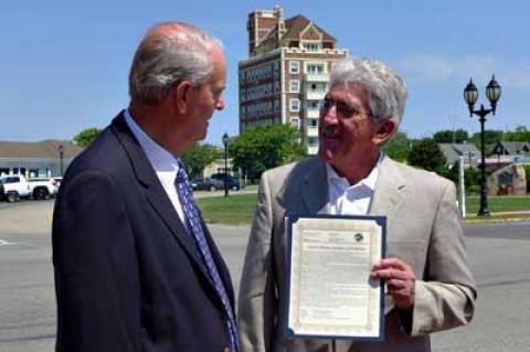 John Keeshan, who successfully lobbied to rename the Plaza after Carl Fisher, received a copy of the East Hampton Town resolution making it official on June 24 from Supervisor Larry Cantwell.