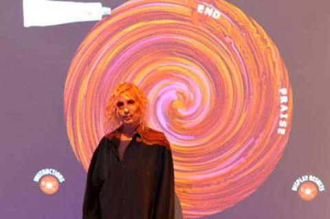 Nina Yankowitz is illuminated by her Vortex Paint Game, one of two interactive games in her Guild Hall installation, “Criss-Crossing the Divine,” that invite viewers to engage in a dialogue with sacred religious texts.