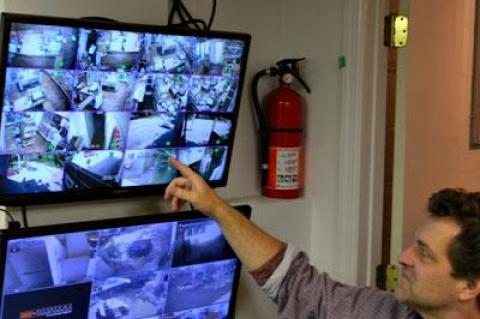 Bruce Damark, a third-generation owner of Damark’s, with monitors for the new surveillance system he put in place to protect the deli.