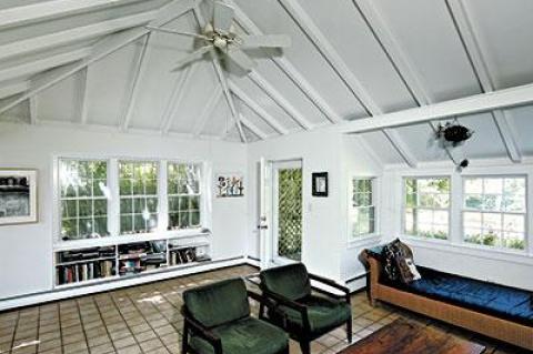 The living room of a model house at Montauk Highway and Gardiner Drive shows the cathedral ceiling, open beams, and built-in bookcases common in these houses.