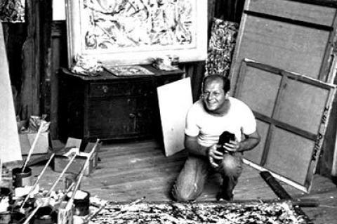 Jackson Pollock held his pet crow, Caw-Caw, in his Springs studio in 1947. “Alchemy,” the painting on the floor, was stretched on his mother’s quilting frame. Part of the frame was recently discovered in Pollock's garage during a restoration project.