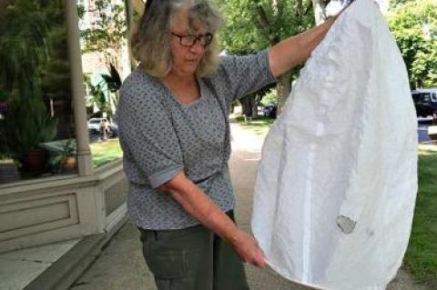 Joan Palumbo, a Montauk resident, holding a Chinese lantern she discovered last week on her roof. It shows an apple-size burn hole.