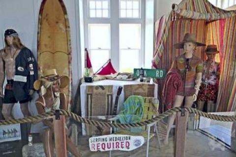 A simulated beach scene is the backdrop for a display of vintage surfboards and memorabilia at the Oceans Institute and Surf Museum at the Montauk Lighthouse.