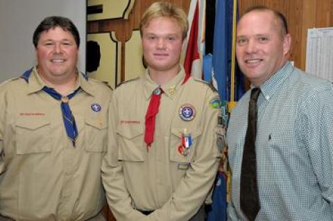 Brenden Snow, center, received his Eagle Scout Award during a ceremony on Sunday attended by many well-wishers including Vincent Franzone, left, who pinned the badge on him, and his father, Scott Snow.