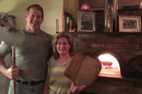 Nancy Hollister and her husband, Owen Jander, who put an addition onto their small Springs house to accommodate the oven, pose as guests arrive for a bimonthly pizza party. Nancy Hollister and her husband, Owen Jander, who put an addition onto their small Springs house to accommodate the oven, pose as guests arrive for a bimonthly pizza party.