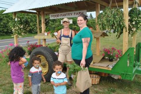 Laura Brady, at right, a member of the Food Pantry Farm’s new working families C.S.A. program, picked up her weekly share of veggies on Monday with some help from her daughter, Laila Sanders, and twins, Chase and Gamble Sanders. At center was Melissa Mapes, a coordinator at the farm.