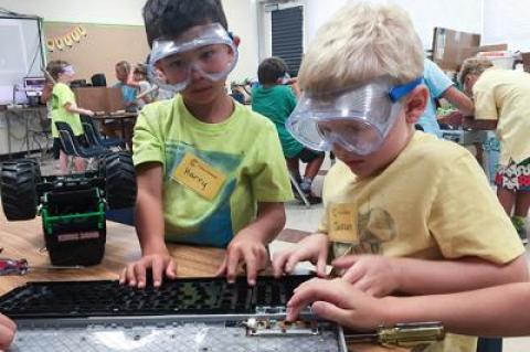 Harry Thomas, left, and Jackson Rogers took apart a broken computer keyboard to see what was inside during an activity called Maker Studio at Camp Invention.