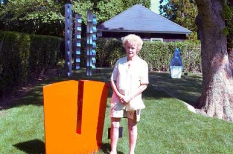 Like much of Carol Ross’s aluminum sculpture, “Gorge,” seen here with the artist in Guild Hall’s sculpture garden, is an abstract, almost Minimalist response to nature.