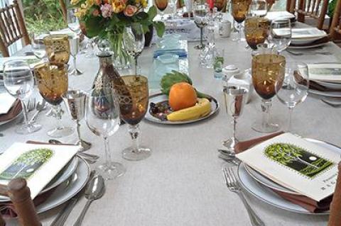 The table is set for last year’s Seder. The artichoke, orange, and banana on the second Seder plate are symbols of contemporary life, and a child’s death.