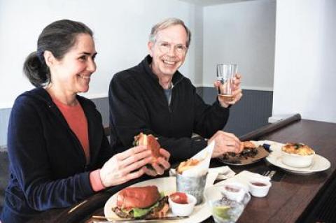 Cynthia and John Kaufmann sampled the pulled pork slider and veggie burger at the Springs Tavern bar, which opened April 1.