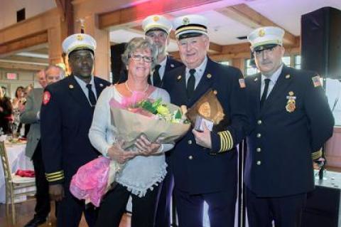 The East Hampton Fire Department chiefs presented Kenny Brown, an ex-chief and active member, with a plaque for his 55 years of service. They also gave his wife, Linda Brown, a bouquet. The chiefs, from left, are Jamalia Hayes, the second assistant chief, Chief Ken Wessberg, and Gerry Turza, the first assistant chief.