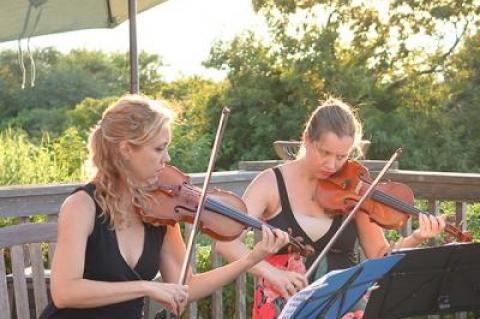 Joanna Maurer and Annaliesa Place performing at an outdoor concert last year