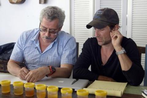 Grigory Rodchenkov, left, and Bryan Fogel conferred behind a palisade of urine samples in the documentary “Icarus.”