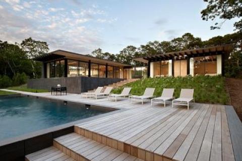 A glass walkway connects the H-shaped house in the Amagansett dunes near Gardiner’s Bay.