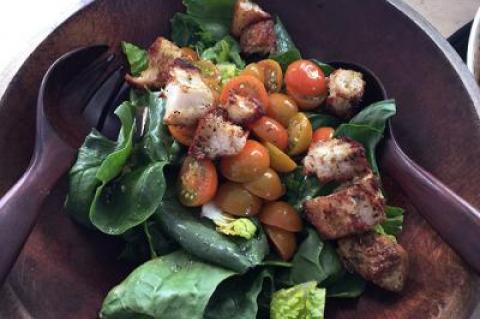 A salad of spinach, romaine, cherry tomatoes, and homemade croutons is a great transitional dish from winter to spring.