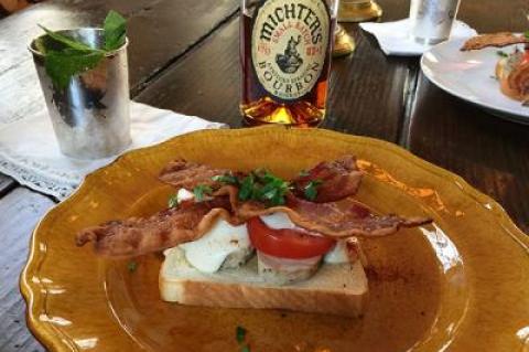 A Kentucky “hot brown” sandwich, above, often follows a day or night of drinking the bourbon-heavy mint juleps seen in the background.