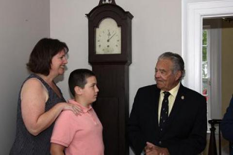 Standing in front of the Dominy clock that they donated to East Hampton Village, Maureen McFall Cayer and her son, David, met with Mayor Paul F. Rickenbach Jr. in the office of Robert Hefner, the village’s director of historic  services, last Thursday.