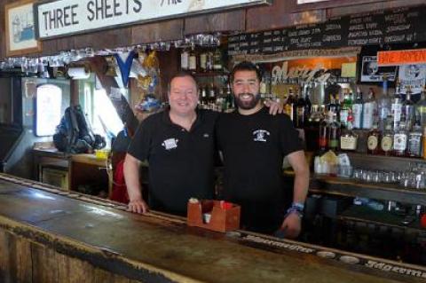 Jay Hamel, the owner of Murf’s Backstreet Tavern, posed with Robert Deery, a bartender. The bar has had to switch its closing time from 4 a.m. to 2 a.m.