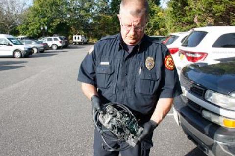 Dwayne Denton, an East Hampton Town fire marshal, held a melted power strip that caught fire in a Springs School classroom on Monday. “This is what can happen when power strips are overloaded,” he said.