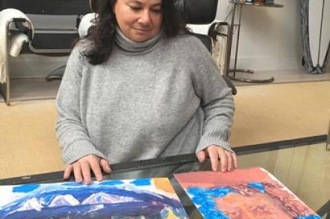 Laura Auerbach, one of 25 volunteers who answered an emergency plea to house the displaced children of a local woman facing deportation, showed some of the paintings her Latino trauma patients have produced in art therapy.