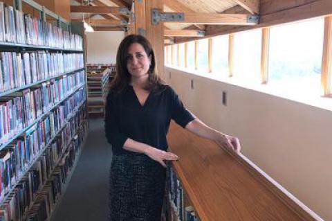 Denise DiPaolo, director of the Montauk Library, in the mezzanine area, which is now open to the main floor of the building. Under a proposed renovation and expansion plan, most of the open areas would be filled in, creating more space on that level and improving acoustics throughout.