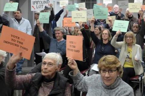 Holding signs and yelling “Shame!” and “No!” a chorus of opponents registered their objections on Tuesday to the Sag Harbor Village Board’s plan for a vehicle impound yard adjacent to the Long Pond Greenbelt.