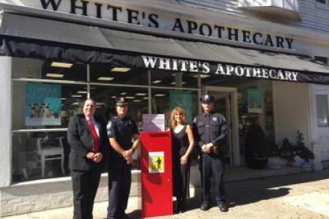 White's Apothecary is sponsoring another "Big Red Med" drug disposal box, to be used by town and village police at community events. From left are Tom McAbee, creator of the Big Red Med disposal box, Sgt. Daniel Roman, Diana Dolling-Ross, owner of White's Apothecary, and Police Officer Kenneth Alversa.