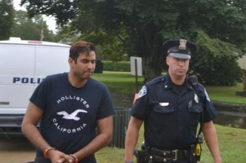 Krishna L. Parihar, who is accused of impersonating a New York City police officer, was led into East Hampton Town Justice Court by Town Police Officer Tim Tierney on Tuesday morning.