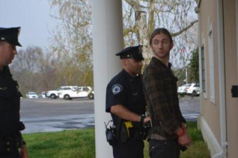 Tyler Armstrong waited for another police officer as he was led into East Hampton Town Justice Court on Saturday.