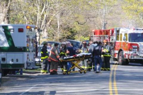 Firefighters and emergency medical workers set up at a house fire.