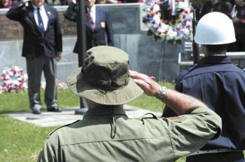 Fred Overton, rear left, commander of East Hampton American Legion Post 419, saluted fellow veterans at the Hook Mill green on Monday.