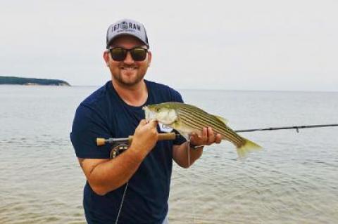 While fly-casting from shore, Harris Stoker landed and released this small striped bass off Navy Beach.