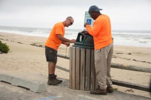 Tony Medeiros and Ray Gilliam of the East Hampton Village Department of Public Works secured garbage can lids in anticipation of high winds associated with Jose.