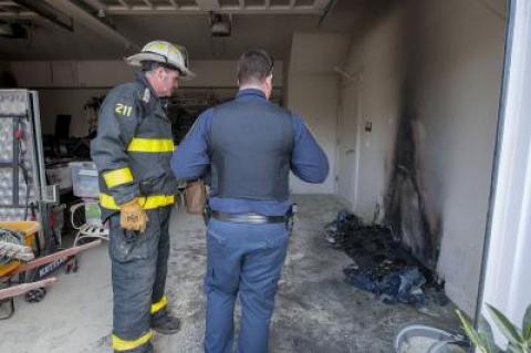 East Hampton Fire Department Assistant Chief Ken Wessberg Jr. and East Hampton Village Police Officer Chris Jack examined the remnants of a fire inside the garage at 29 Pondview Lane in East Hampton on Monday.