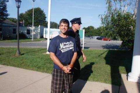 Andrew D. Hellman, 36, smiled for the photographer as he was led into East Hampton Justice Court earlier this month to face charges that included injuring a police officer.