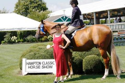 Iris Smyles awarded The East Hampton Star-sponsored Local Hunter Pro Hampton Classic championship prize to Holly Orlando on O.