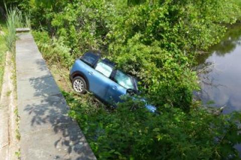 A Mini Cooper was apparently abandoned by its driver after it ran off the road in East Hampton Village and came to rest down an embankment in a Hook Pond tributary.