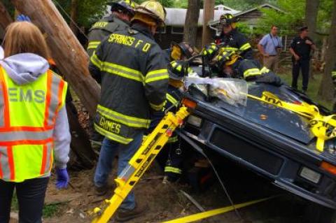 The Springs Fire Department worked to extricate two people from a Porsche that crashed into a utility pole on Three Mile Harbor-Hog Creek Road on Saturday afternoon.