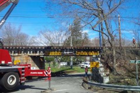 A crane with a boom approximately 80 feet long was brought in to make repairs to the train trestle after it was struck on Monday morning.