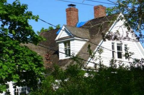 A blue plastic tarp covered a portion of the roof of an Amagansett house that was damaged in a fire on Saturday night.