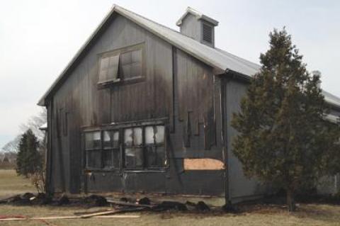 Firefighters put out a grass fire on Wednesday at the Hayground School in Bridgehampton that had reached a kitchen building and was climbing an outside wall.