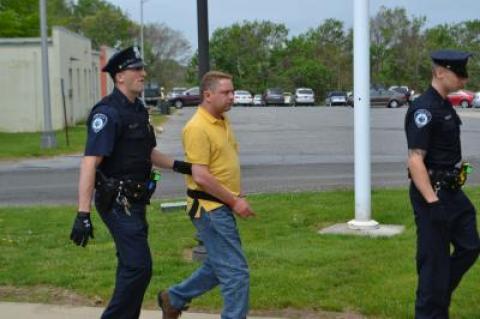 East Hampton Town police led Philip Porpora to his arraignment at town justice court Saturday.