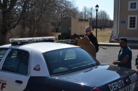 Joseph R. Spezzano ducks his head as he gets into a Suffolk County Deputy Sheriff's vehicle for the county jail, where he will spend the next six months.