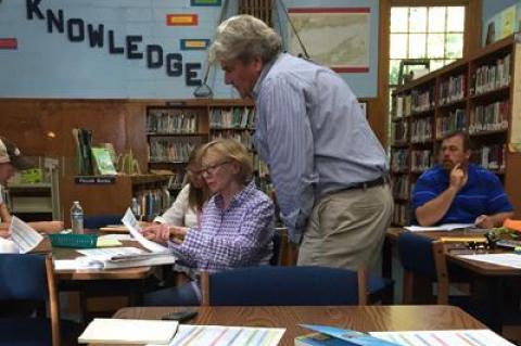 Roger Smith, a principal with BBS Architects and Engineers, assisted Pamela Bicket, a member of the Springs School facilities committee, at a meeting last year.