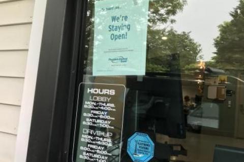 A sign at the drive-through window alerted customers that the bank will remain open.