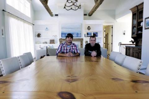 Jason Biondo, left, and Donnie Disbrow crafted this massive live-edge table in a Montauk client’s house from an old-growth eastern white pine using a technique called bookmatching, in which a thick slab is cut down the middle and fitted together so that both sides of the piece are almost mirror images of each other. They built a kitchen island in the house from the same tree.