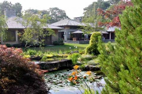 The main house, with cues from Japanese architecture and Frank Lloyd Wright, is large but nestled into the landscape. It faces part of the water garden.