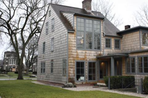 The house was extended to the rear, and the attic was removed to allow the second-floor master bedroom to soar behind double-height windows.